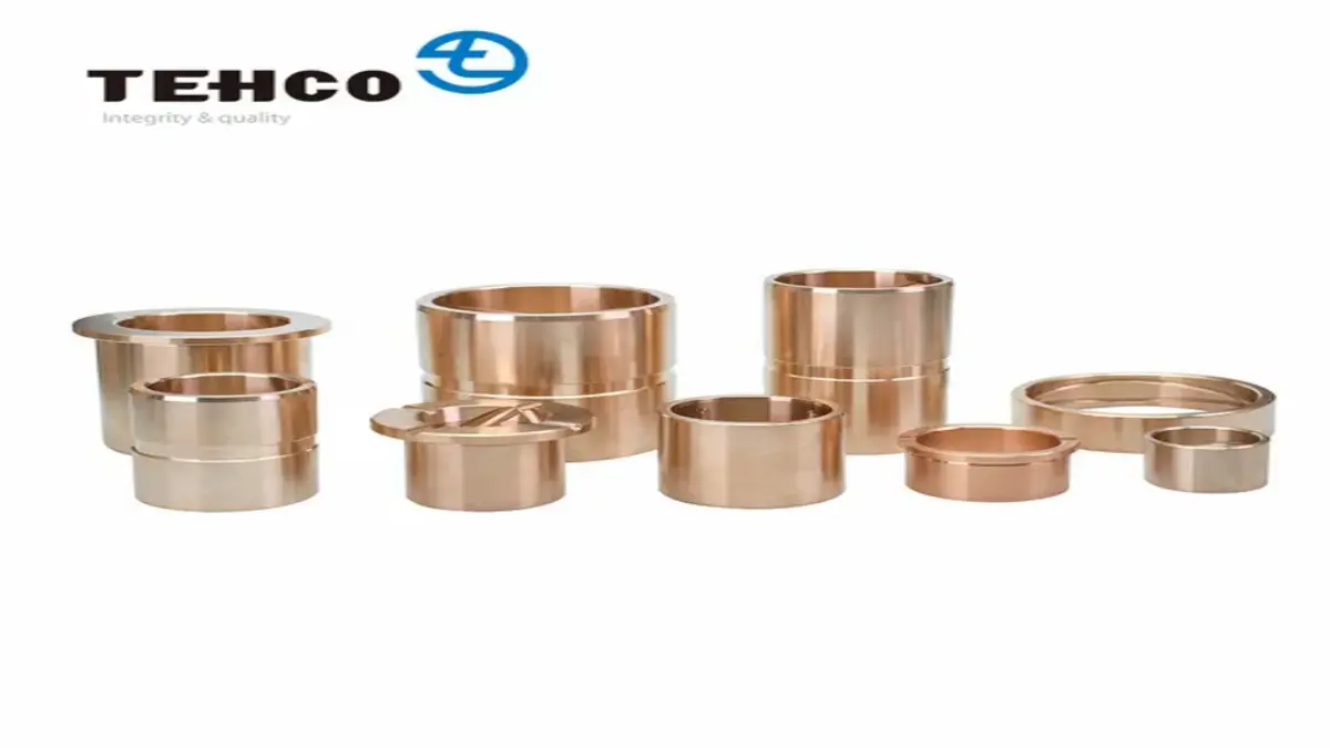 Multiple bronze-colored cylindrical bushings arranged in rows on a white background.