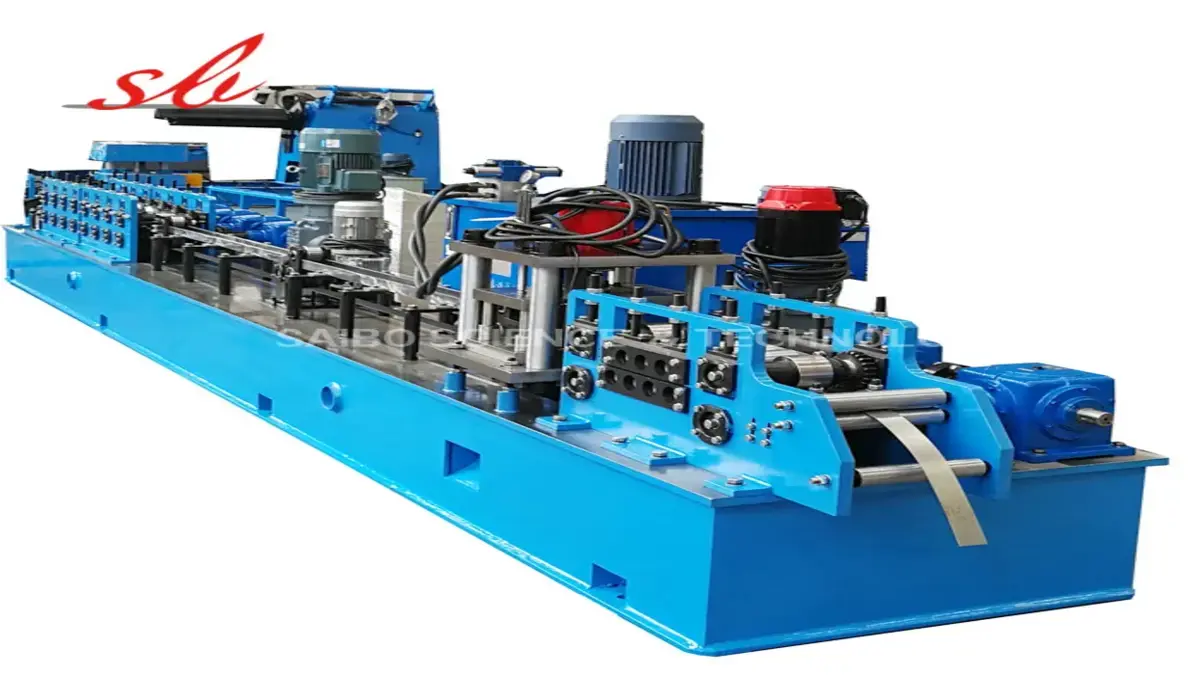 Blue industrial metal forming machine processing narrow metal strip in a workshop setting.